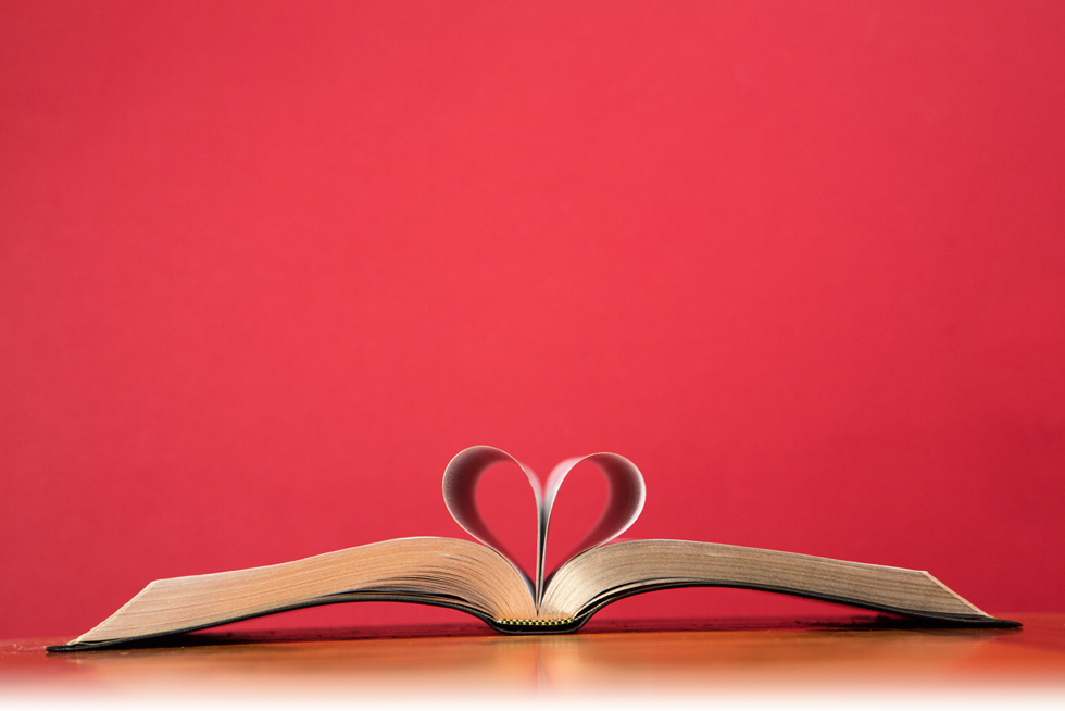 book with pages turned into a heart agains a red background